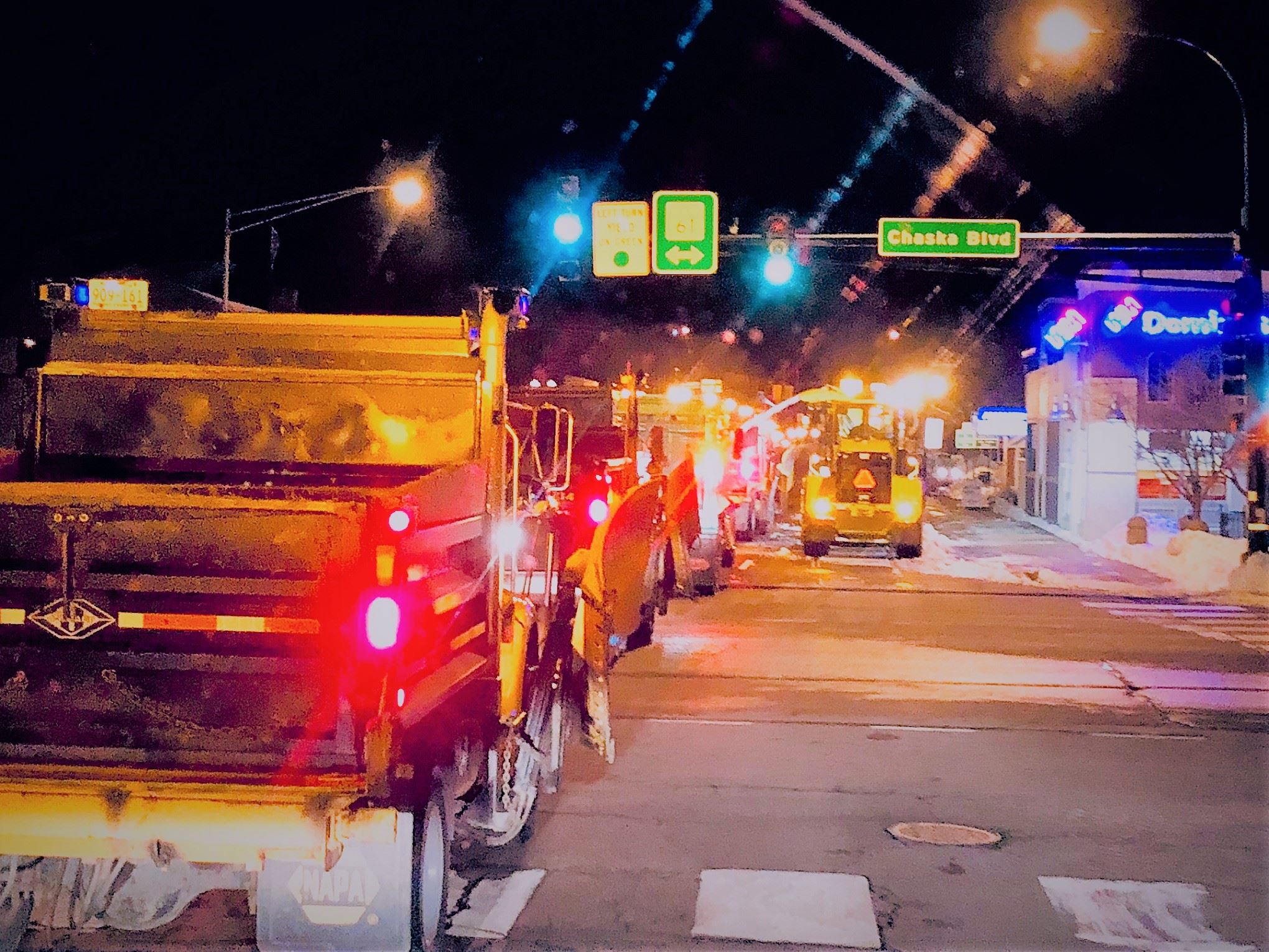 Snow plow trucks lined up on downtown street