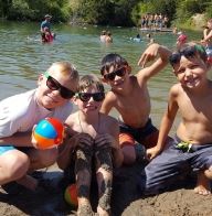 Group of boys sitting in the sand at the beach