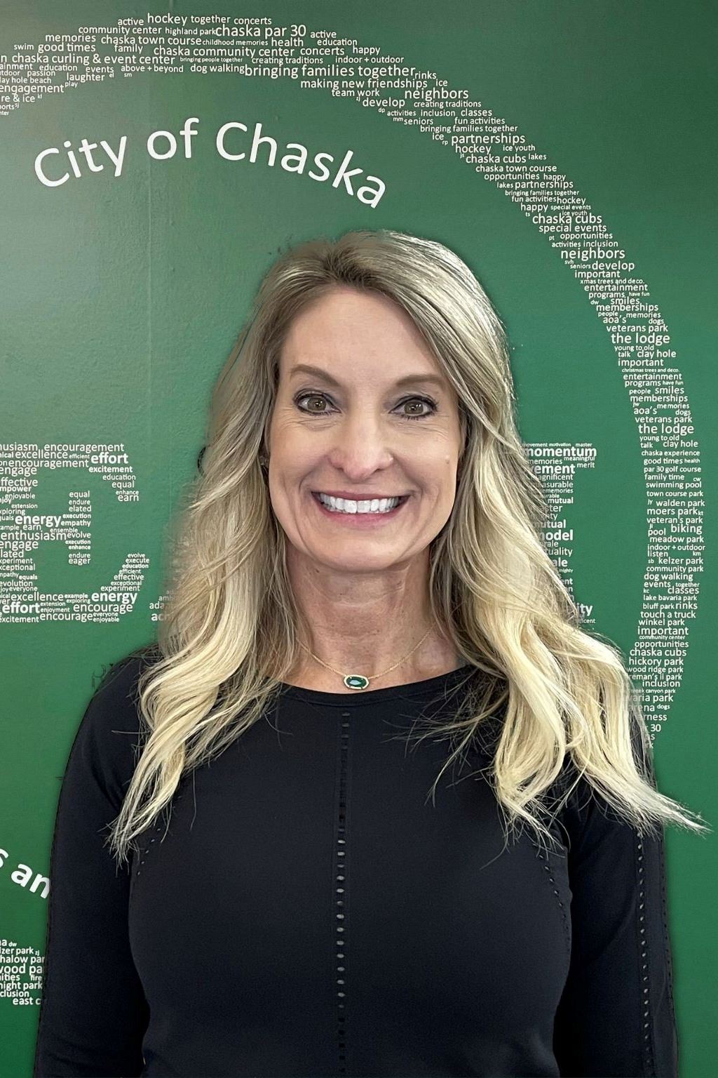 Personal Trainer Missy Frick in black shirt standing in front of green TEAM sign
