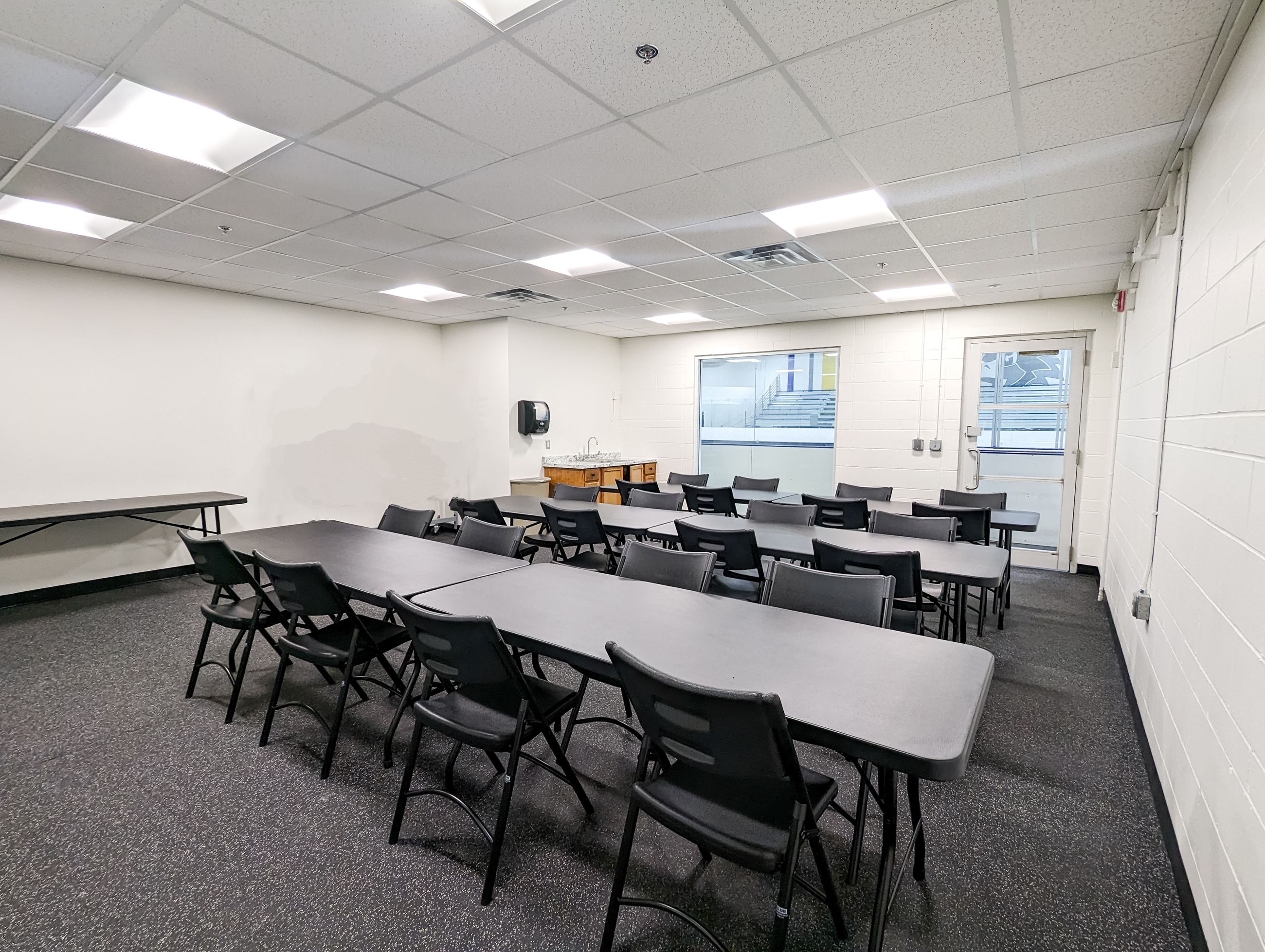 Rink Side room with tables and chairs set up , view of ice arena through window